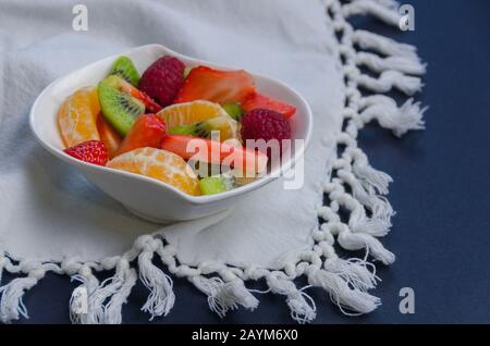 Fruistscheiben in eine weiße Schüssel geben. Stockfoto