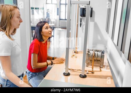Studentinnen, die im modernen Labor experimentelle Arbeiten auf dem Gebiet der Mechanik und Physik anstellen Stockfoto