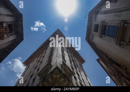 Unterste Ansicht der alten Gebäude mit blauer Beleuchtung. Niedrige Blickwinkel auf die Flares hoher Kolonialgebäude. Stockfoto