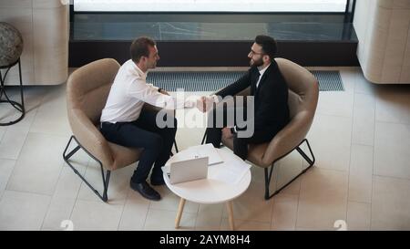 Horizontal über dem Blick auf europäische und arabische Geschäftsleute, die mit einem Treffen beginnen Stockfoto