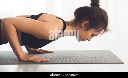 Frau, die im Studio planke Übungen macht oder Push ups macht Stockfoto