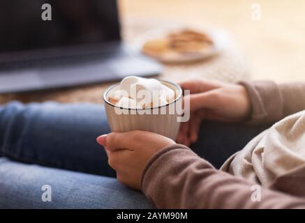 Mädchen, die zu Hause heiße Schokolade mit Marshmallows genießen Stockfoto