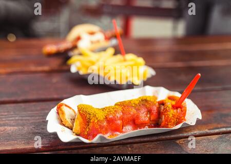 Deutsche Curry-Wurst mit pommes frites, Straßennahrungskonzept Stockfoto