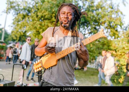 Berlin, DEUTSCHLAND - 20. MAI 2018: Musikermann singt und spielt Gitarre auf der Stadtstraße Stockfoto