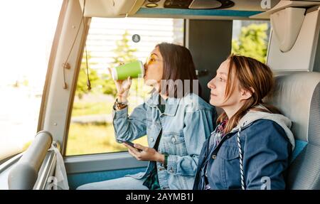 Zwei Mädchen fahren mit dem Bus in Europa, mit öffentlichen Verkehrsmitteln, Reise- und Urlaubs- und Freundschaftskonzept Stockfoto