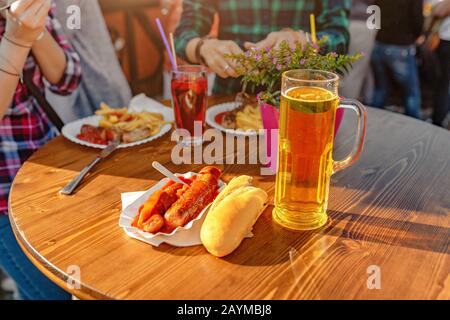 Curry-Wurst mit Bier auf dem Tisch im Außenrestaurant Stockfoto