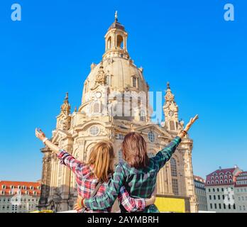 Zwei glückliche Frauen umarmen und betrachten die Hauptattraktion der Frauenkirche. Das Konzept der Liebe und Freundschaft auf Reisen Stockfoto