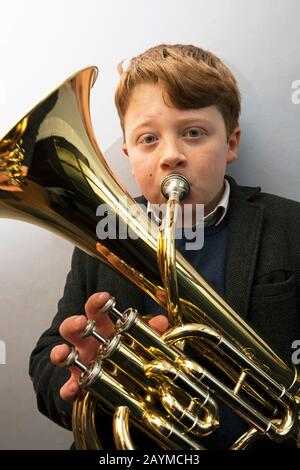 Der 12-jährige Junge spielt ein Bariton-Horn Stockfoto