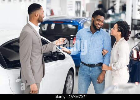 Familie Kauft Auto Taking Key Vom Autohändler Im Geschäft Stockfoto