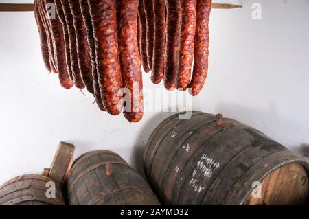 Frisch geräucherte Würstchen und Wein in einem Fass in einem Keller für den Urlaub Stockfoto