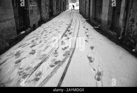 Der Mensch fegt Schnee von der städtischen Straße, vom Winter und von der Arbeit Stockfoto