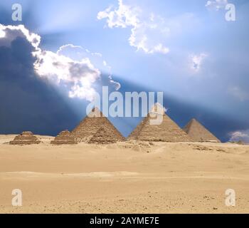 Die Sonne scheint von Wolken über dem Giza-Pyramidenkomplex oder der Giza-Necropolis auf dem Giza-Plateau in Ägypten bei Kairo, einschließlich der Großen Pyramide von Giz Stockfoto