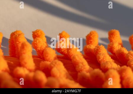 Wunderschönes Mikrofasertuch, leuchtend orangefarbene Mikrofaser. Mikrofaserstruktur mit einem weichen, großen Haufen. Oberflächenstruktur aus orangefarbenem Mikrofasergewebe Stockfoto