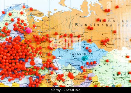Riesige Anzahl roter Pins in Europa und anderen Kontinenten auf einer Weltkarte mit flachem DoF Stockfoto