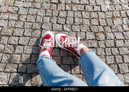 Draufsicht auf Turnschuhe, die auf dem Straßenbelag stehen Stockfoto