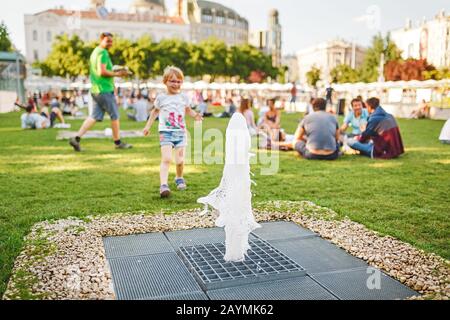 13. MAI 2018, BUDAPEST, UNGARN: Menschenmenge, die sich im Urlaub in der Innenstadt auf dem grünen Gras entspannt Stockfoto