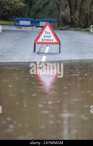 Majors Green, Birmingham, Großbritannien. Februar 2020. Ein Schild, mit dem Sie Ihre Bremsen testen sollten, nachdem Sie eine Überschwemmung auf der Peterbrook Road in Majors Green, Birmingham verlassen haben, während der Fluss durch die Starkregen vom Sturm Dennis seine Ufer platzte und die Straße für alle außer Spezialfahrzeuge gesperrt hat. Bild aufgenommen am 16.02.2020. Quelle: Stop Press Media/Alamy Live News Stockfoto