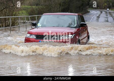 Majors Green, Birmingham, Großbritannien. Februar 2020. Ein Range Rover fährt durch eine überflutete Peterbrook Road in Majors Green, Birmingham, als der Fluss aufgrund der starken Regenfälle vom Sturm Dennis seine Ufer platzt und die Straße für alle außer Spezialfahrzeuge gesperrt ist. Bild aufgenommen am 16.02.2020. Quelle: Stop Press Media/Alamy Live News Stockfoto