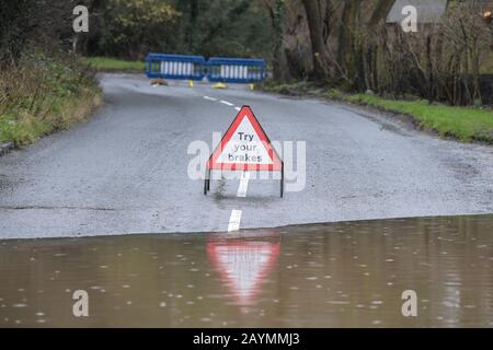 Majors Green, Birmingham, Großbritannien. Februar 2020. Ein Schild, mit dem Sie Ihre Bremsen testen sollten, nachdem Sie eine Überschwemmung auf der Peterbrook Road in Majors Green, Birmingham verlassen haben, während der Fluss durch die Starkregen vom Sturm Dennis seine Ufer platzte und die Straße für alle außer Spezialfahrzeuge gesperrt hat. Bild aufgenommen am 16.02.2020. Quelle: Stop Press Media/Alamy Live News Stockfoto