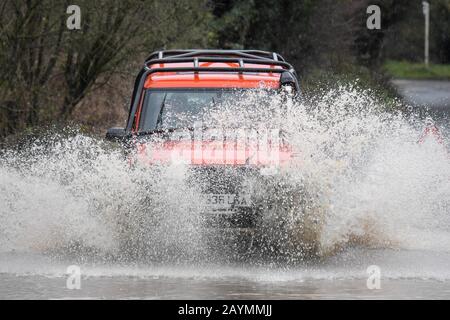 Majors Green, Birmingham, Großbritannien. Februar 2020. Ein Fahrer eines umgebauten Landrover Discovery macht sich auf den Weg durch eine überflutete Peterbrook Road in Majors Green, Birmingham, als der Fluss aufgrund von starken Regenfällen vom Sturm Dennis seine Ufer platzt und die Straße für alle außer Spezialfahrzeuge gesperrt. Bild aufgenommen am 16.02.2020. Quelle: Stop Press Media/Alamy Live News Stockfoto