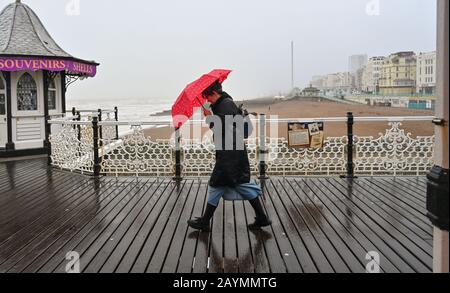 Brighton UK 16. Februar 2020 - Besucher, die dem Wetter für einen Spaziergang auf dem Brighton Palace Pier trotzen, während Storm Dennis heute starken Regen und starken Wind aus der Galeere in die meisten Gegenden Großbritanniens bringt: Credit Simon Dack / Alamy Live News Stockfoto