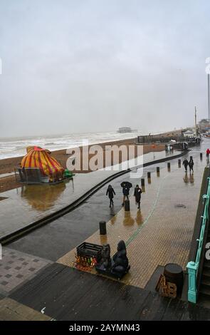 Brighton UK, 16. Februar 2020 - Besucher, die dem Wetter für einen Spaziergang an der Küste von Brighton trotzen, während Sturm Dennis heute starken Regen und starken Wind aus der Galeere in die meisten Gegenden Großbritanniens bringt: Credit Simon Dack / Alamy Live News Stockfoto