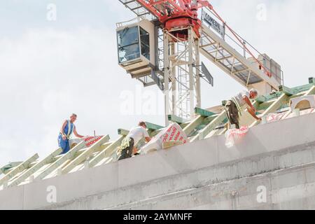 14. MAI 2018, BUDAPEST, UNGARN: Die Arbeiter auf dem Dach sind vor dem Hintergrund eines Krans mit der Reparatur und Isolierung von Bauwerken beschäftigt Stockfoto