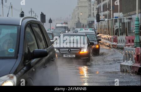 Brighton UK 16. Februar 2020 - Der Verkehr fährt durch Flutwasser an der Küste von Brighton, während der Sturm Dennis heute starken Regen und starken Wind der Sturmstärke in die meisten Gegenden Großbritanniens bringt: Credit Simon Dack / Alamy Live News Stockfoto