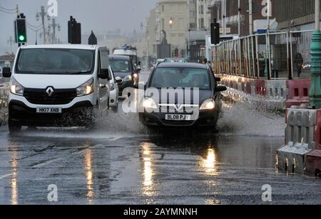 Brighton UK 16. Februar 2020 - Der Verkehr fährt durch Flutwasser an der Küste von Brighton, während der Sturm Dennis heute starken Regen und starken Wind der Sturmstärke in die meisten Gegenden Großbritanniens bringt: Credit Simon Dack / Alamy Live News Stockfoto