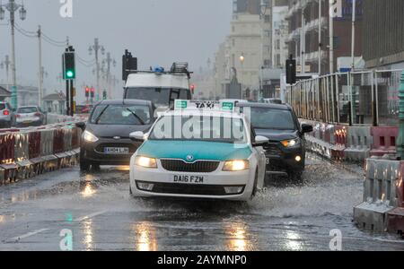 Brighton UK 16. Februar 2020 - Der Verkehr fährt durch Flutwasser an der Küste von Brighton, während der Sturm Dennis heute starken Regen und starken Wind der Sturmstärke in die meisten Gegenden Großbritanniens bringt: Credit Simon Dack / Alamy Live News Stockfoto