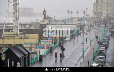 Brighton UK 16. Februar 2020 - EIN paar mutige Besucher trotzen dem Wetter an der Küste von Brighton, da Sturm Dennis heute starken Regen und starken Wind aus der Galeere in die meisten Gegenden Großbritanniens bringt: Credit Simon Dack / Alamy Live News Stockfoto