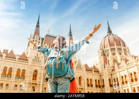 Fröhliche asiatische Casual Woman Studentin mit großartigem Blick auf das Parlamentsgebäude in der Stadt Budapest, Reise in Europa Konzept Stockfoto