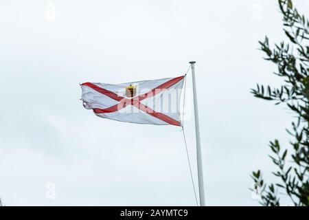Die Flagge von Jersey (Kanalinseln) schrampelt im Wind von Sturm Dennis Stockfoto
