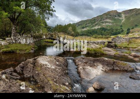 Slater's Bridge, eine wunderschöne kleine Schiefer Packhorse Brücke, über River Brathay, Little Langdale, Lake District, Cumbria, England, Großbritannien Stockfoto