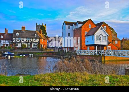 Dieser hübsche Blick auf den Fluss der alten Cottages am Fluss und die Wassermühle von Tewkesbury am Fluss Avon bietet einen Blick auf die Abbey im Hintergrund. Stockfoto