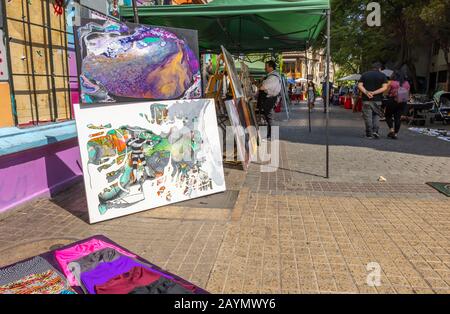 Straßenszene im Zentrum von Santiago, Metropolitan Region, Hauptstadt von Chile, Südamerika, abstrakte Gemälde zum Verkauf auf einem lokalen Streetside Market Stockfoto