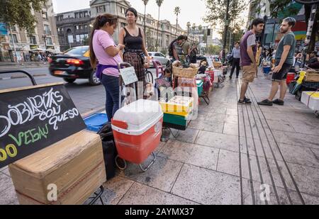 Vegane und Straßennahrung aus kleinen Ständen auf dem Bürgersteig am Abend in Lastarria, Central Santiago, Metropolitan Region, Hauptstadt von Chile Stockfoto