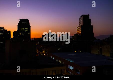 Santiago, Metropolitan Region, Hauptstadt von Chile, Südamerika, Skyline mit Silhouettenbauten, die von Lastarria bei Einbruch der Dunkelheit gesehen werden, während die Sonne untergeht Stockfoto