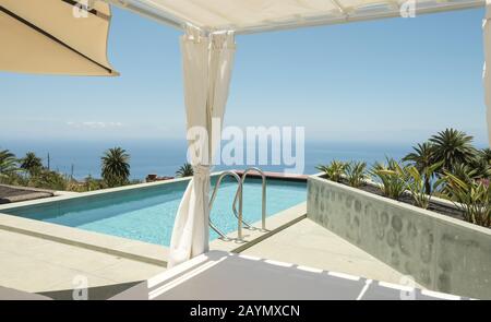 Blick auf den Swimmingpool und das Meer (tagsüber) von einer Luxusvilla in der Nähe von La Punta, auf La Palma, Kanarische Inseln, Spanien. Stockfoto