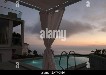Blick auf den Swimmingpool und das Meer in der Abenddämmerung von einer Luxusvilla in der Nähe von La Punta, auf La Palma, Kanarische Inseln, Spanien. Stockfoto