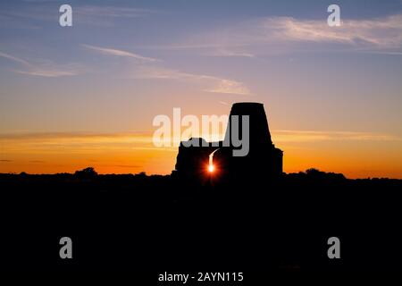 Die Ruinen von St. Benet's Abbey Torhouse und Derelict Mill am Fluss Bure auf den Norfolk Broads bei Sonnenuntergang. Stockfoto