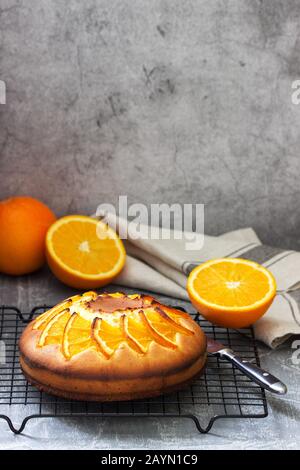 Orangenkuchen mit Orangenscheiben auf Betongrund. Stockfoto