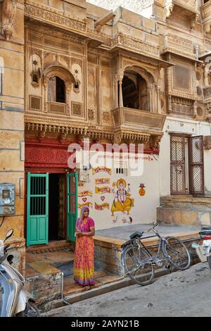 Frau vor dem farbenfrohen Haveli in Jaisalmer, Rajasthan, Indien Stockfoto