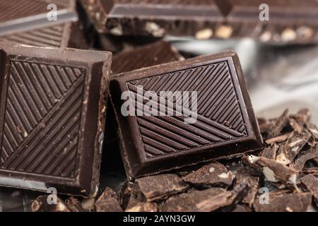 Schokoladenriegel pats Stücke Hintergrund mit Mandelnuss, nah oben Stockfoto