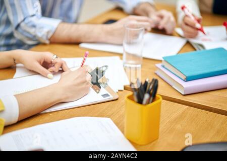 Zugeschnittenes Bild einer Psychiater-odr-Geschäftsfrau, die während der Besprechung, Konferenz, Papierarbeit, Beruf und Beruf Notizen macht Stockfoto