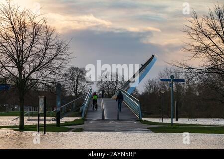 Wetter in Großbritannien. Pendler gehen über die Millennium Bridge am überfluteten Fluss Ouse in York vorbei. Stockfoto