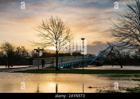 Wetter in Großbritannien. Pendler gehen über die Millennium Bridge am überfluteten Fluss Ouse in York vorbei. Stockfoto