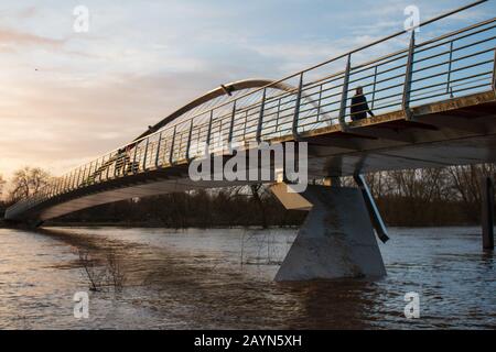 Wetter in Großbritannien. Pendler gehen über die Millennium Bridge am überfluteten Fluss Ouse in York vorbei. Stockfoto