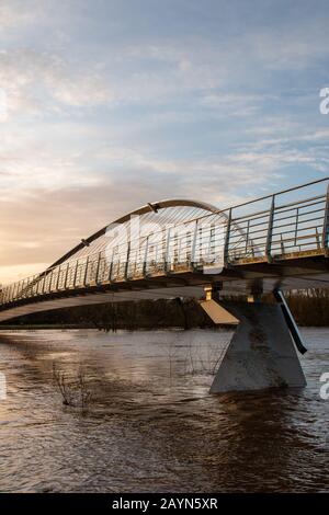 Wetter in Großbritannien. Pendler gehen über die Millennium Bridge am überfluteten Fluss Ouse in York vorbei. Stockfoto