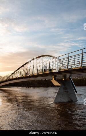 Wetter in Großbritannien. Pendler gehen über die Millennium Bridge am überfluteten Fluss Ouse in York vorbei. Stockfoto